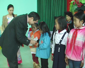 Đại diện trường ĐH khoa học xã hội và nhân văn Hà Nội tặng quà cho các em học sinh huyện vùng cao Đà Bắc.